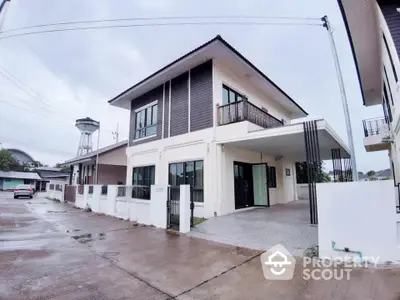 Modern two-story house with carport and large windows in a suburban neighborhood