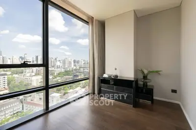 Stunning corner unit with floor-to-ceiling windows offering panoramic city views, elegant hardwood floors, and modern decor.