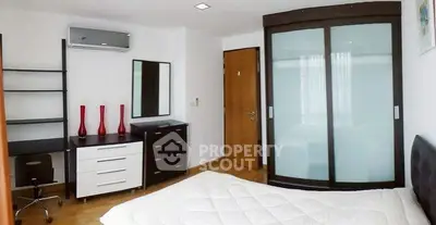 Modern bedroom with sleek furniture and ample storage space.
