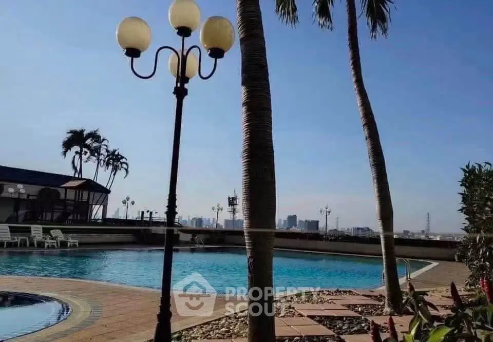 Luxurious rooftop pool with stunning city views and palm trees, perfect for relaxation and leisure.