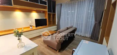 Modern living room with cozy sofa, TV, and elegant curtains