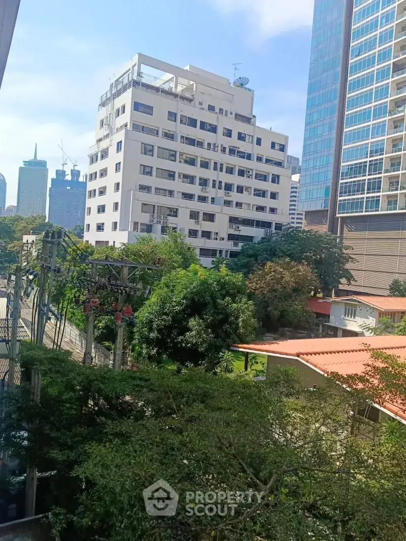 Urban cityscape view with modern buildings and lush greenery, perfect for real estate investment.