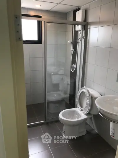 Modern bathroom with glass shower and sleek fixtures in a compact layout.