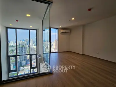 Spacious corner unit with stunning city view and floor-to-ceiling windows in modern high-rise building.