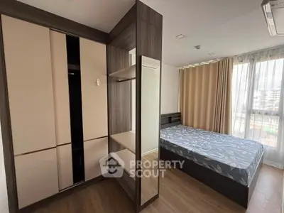 Modern bedroom with stylish wardrobe and large window offering natural light.