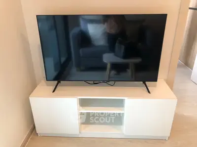 Modern living room with sleek TV setup on stylish white console, perfect for entertainment.