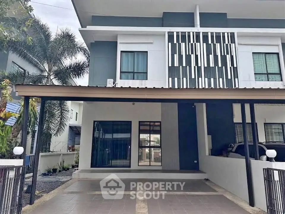 Modern two-story house with spacious carport and stylish facade in a serene neighborhood.