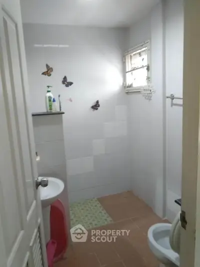 Cozy bathroom with butterfly decor and compact layout, ideal for small spaces.