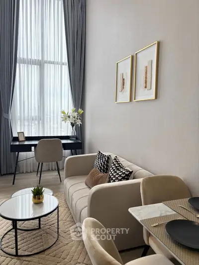 Elegant living room with high ceiling, modern furniture, and large window for natural light.