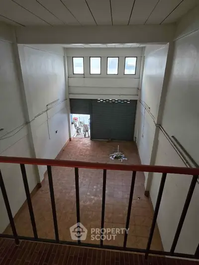 Spacious commercial space with high ceiling and large windows, ideal for retail or office use.