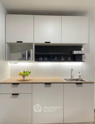 Modern kitchen with sleek cabinetry and under-cabinet lighting, featuring a minimalist design.