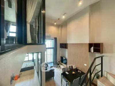 Modern loft-style living room with high ceilings and large windows