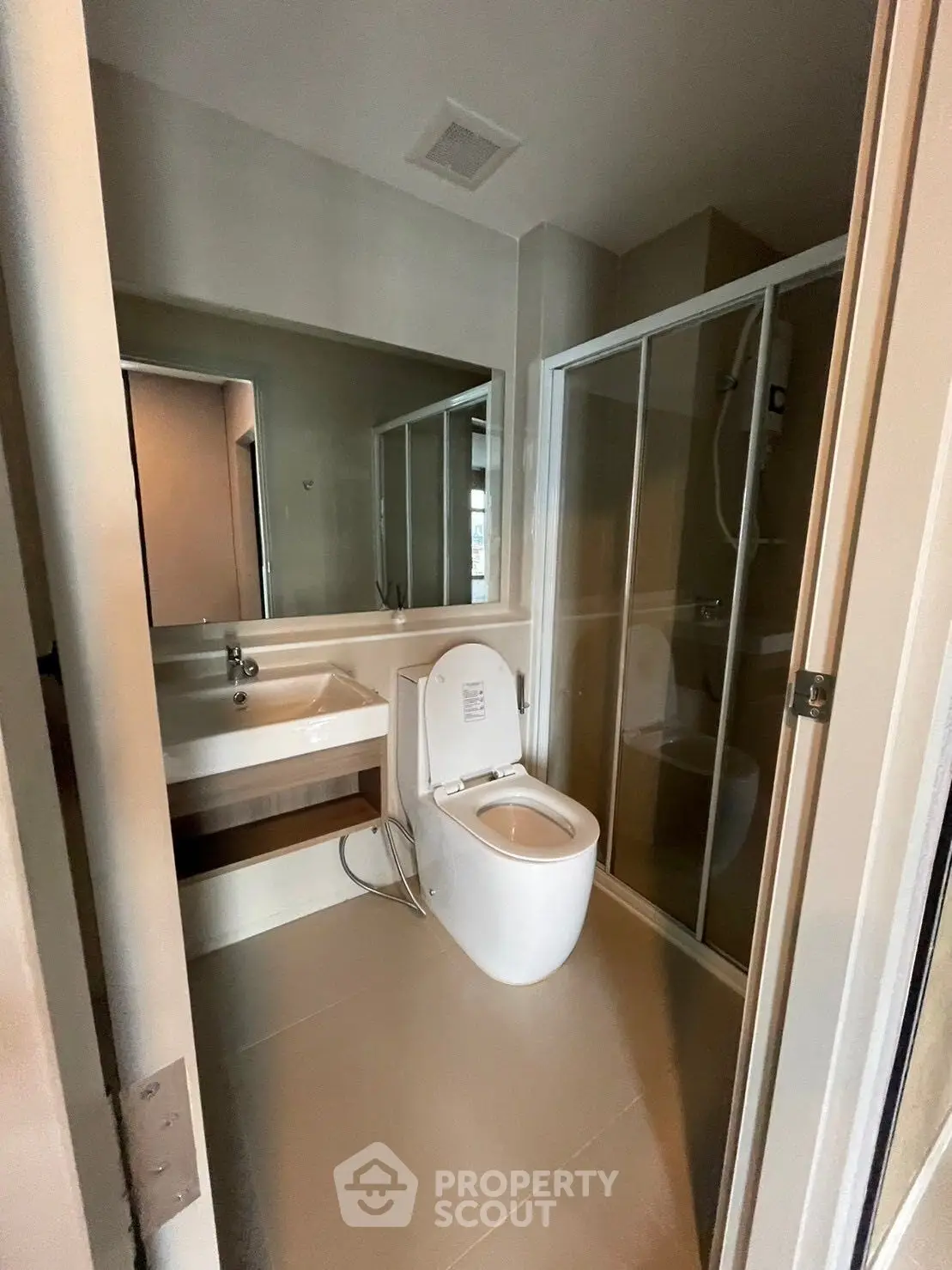 Modern bathroom with glass shower and sleek fixtures in a contemporary apartment.
