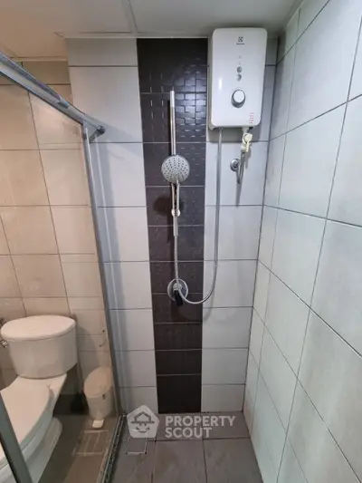 Modern bathroom with sleek shower and water heater, featuring stylish tile design.