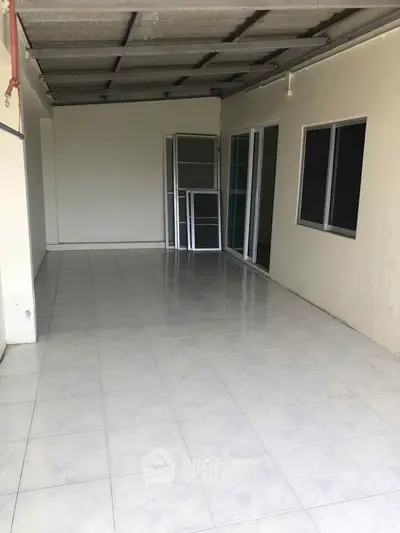 Spacious tiled balcony area with sliding glass doors, perfect for outdoor relaxation.