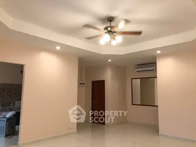 Spacious living room with ceiling fan and modern lighting