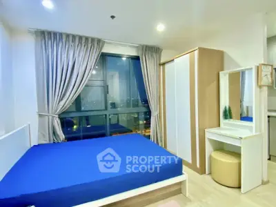 Modern bedroom with large window and stylish furniture in urban apartment.