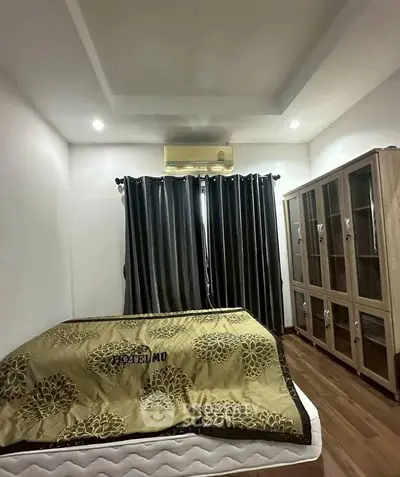 Cozy bedroom with modern decor, featuring a comfortable bed, elegant curtains, and stylish wooden cabinet.
