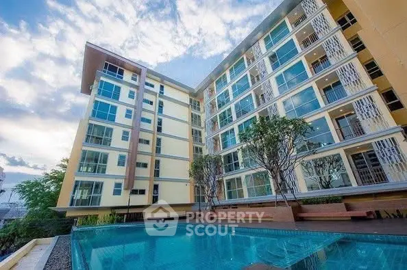 Modern apartment building with a stunning pool and lush greenery, perfect for luxury living.