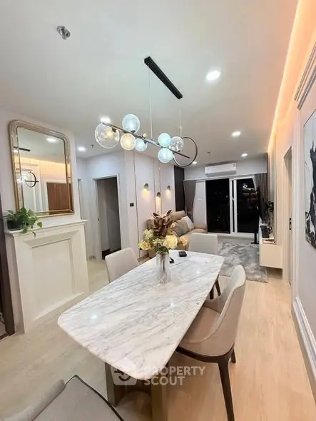 Elegant modern living room with stylish dining area and contemporary lighting.