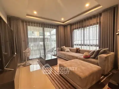 Spacious modern living room with plush sofas and large windows offering natural light.