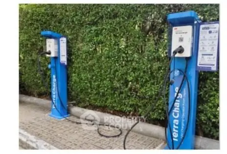 Electric vehicle charging stations in a green landscaped area.