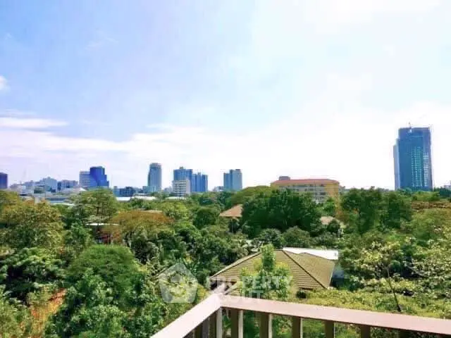 Stunning cityscape view from a high-rise balcony overlooking lush greenery and urban skyline.