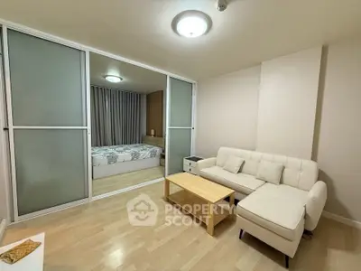 Modern living room with sliding doors leading to a cozy bedroom, featuring a stylish sofa and wooden flooring.