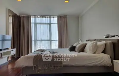 Spacious bedroom with large windows offering ample natural light, a king-sized bed, and modern furnishings for a luxurious living experience.