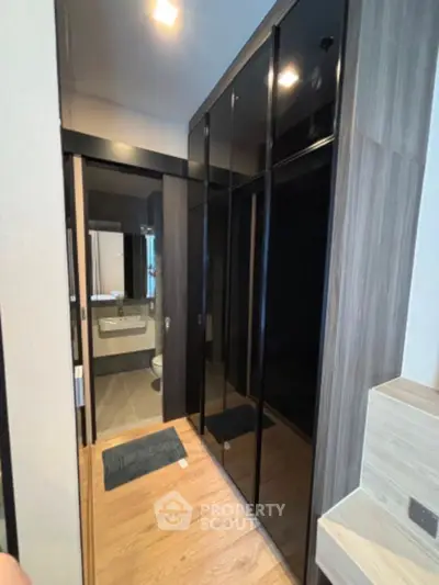 Modern bathroom with sleek black cabinetry and wood flooring