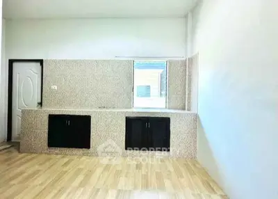 Spacious kitchen with modern design and ample natural light, featuring sleek cabinetry and tiled backsplash.