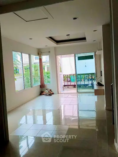 Spacious living room with large windows and balcony access, perfect for natural light lovers.