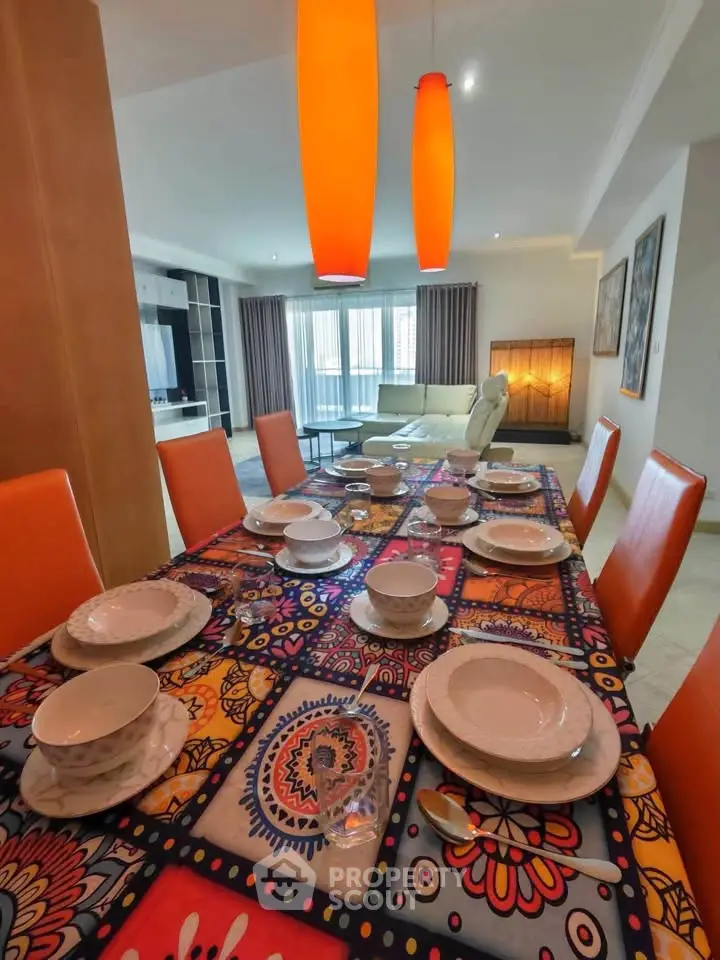 Spacious dining area with vibrant table setting and modern lighting in a stylish open-plan living room.