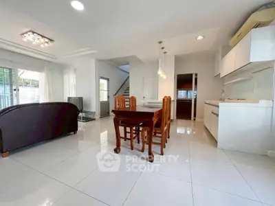 Spacious open-plan living and dining area with modern kitchen in a bright, airy home.