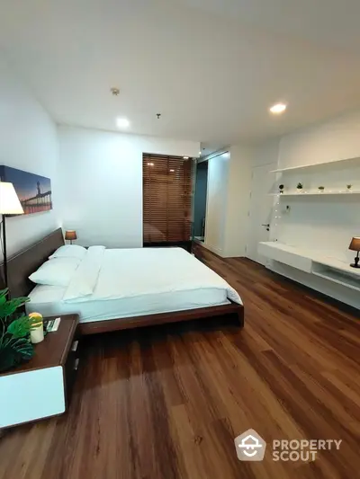 Spacious modern bedroom with wooden flooring and elegant decor