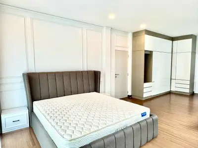 Spacious bedroom with modern design and elegant furnishings, featuring a large bed and ample storage space.