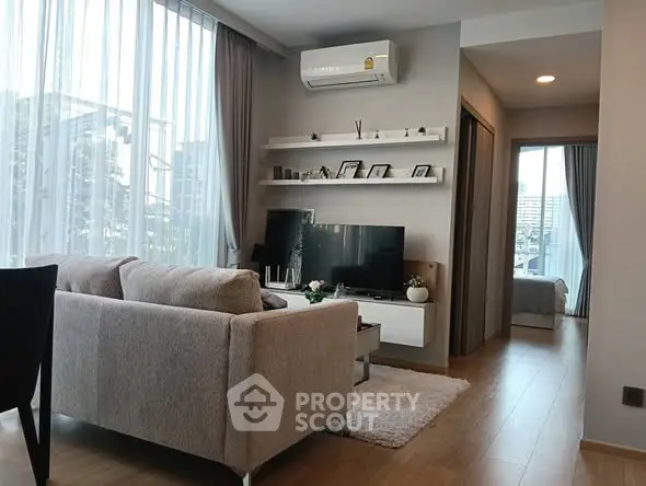 Modern living room with large windows and cozy furniture in a stylish apartment.
