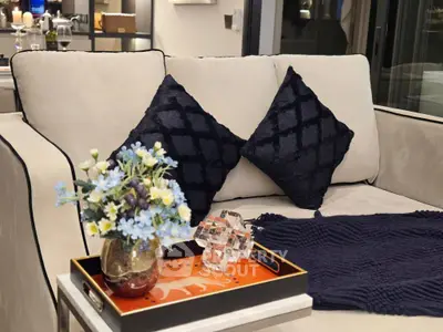 Elegant living room with plush sofa, decorative pillows, and stylish floral arrangement.