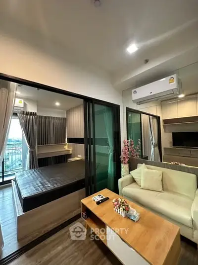 Modern studio apartment with glass partition, cozy living area, and balcony view.