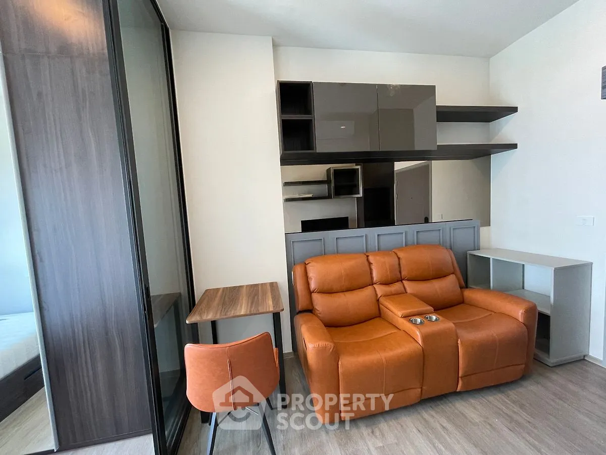 Modern living room with stylish leather sofa and sleek shelving in a cozy apartment.