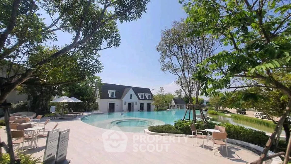 Luxurious outdoor pool area with lush greenery and modern seating, perfect for relaxation.