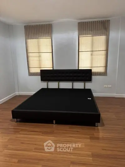 Spacious bedroom with modern bed frame and wooden flooring