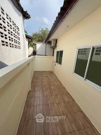 Charming outdoor balcony with tiled flooring and air conditioning unit, perfect for relaxation.