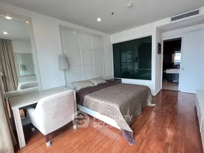Modern bedroom with wooden flooring and stylish decor in a contemporary apartment.