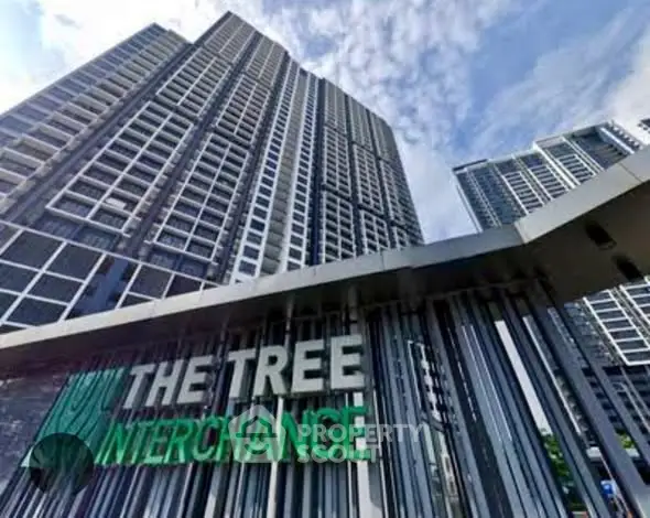 Modern high-rise building with sleek design and prominent signage under a clear blue sky.