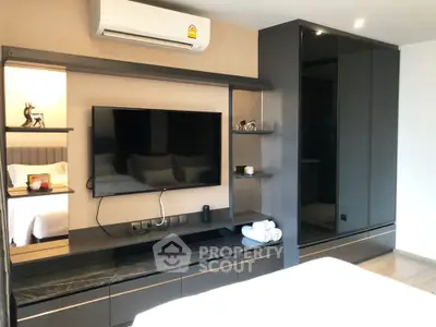 Modern bedroom with sleek TV unit and air conditioning, perfect for comfortable living.