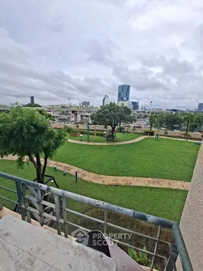 Spacious urban garden view from balcony with city skyline backdrop
