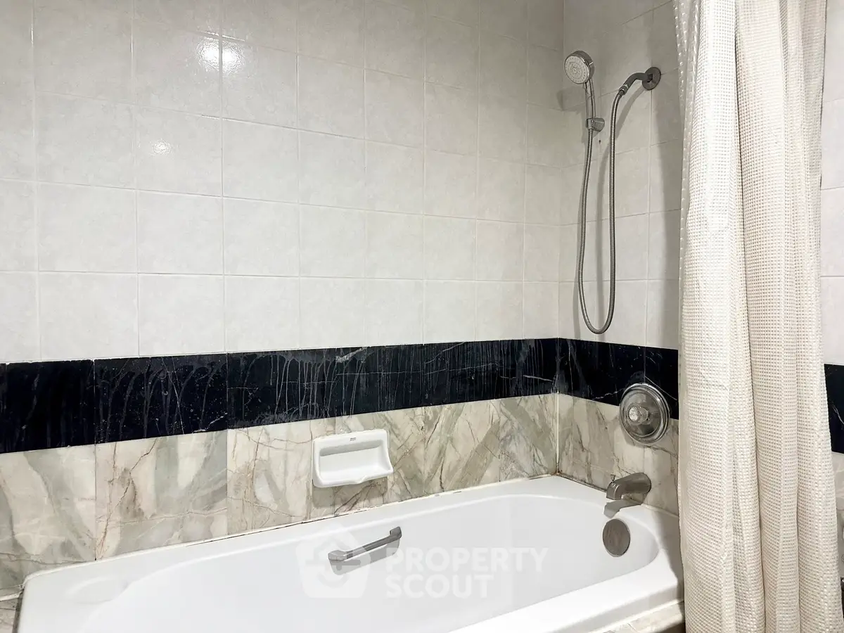 Elegant bathroom with marble accents and modern shower fixtures, perfect for relaxation.
