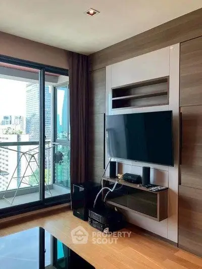 Modern living room with sleek TV setup and city view balcony