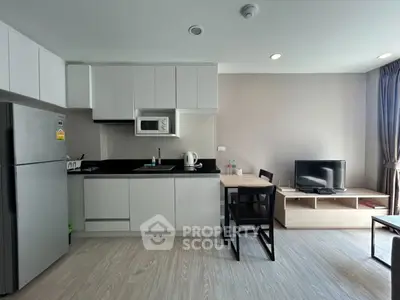 Modern kitchen and living area with sleek appliances and cozy dining space.